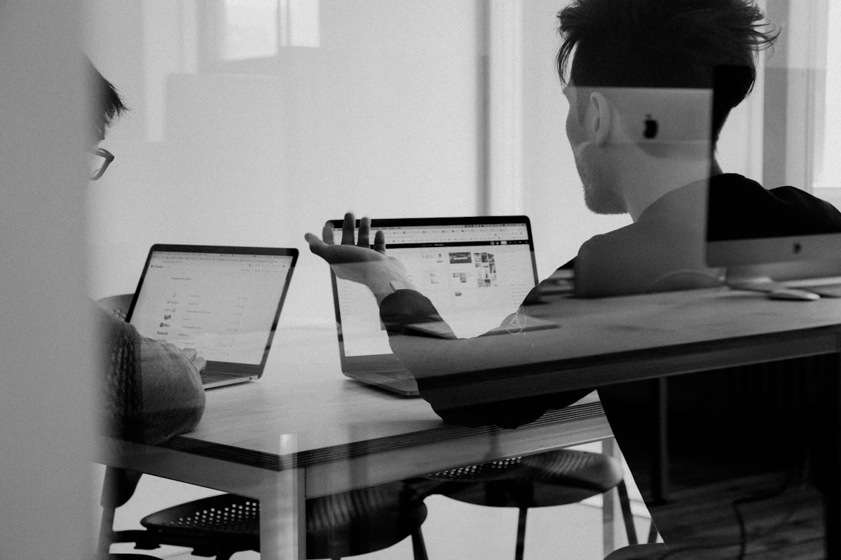 A desk covered in open tools and screens — the seam-heavy setup that creates shadow work