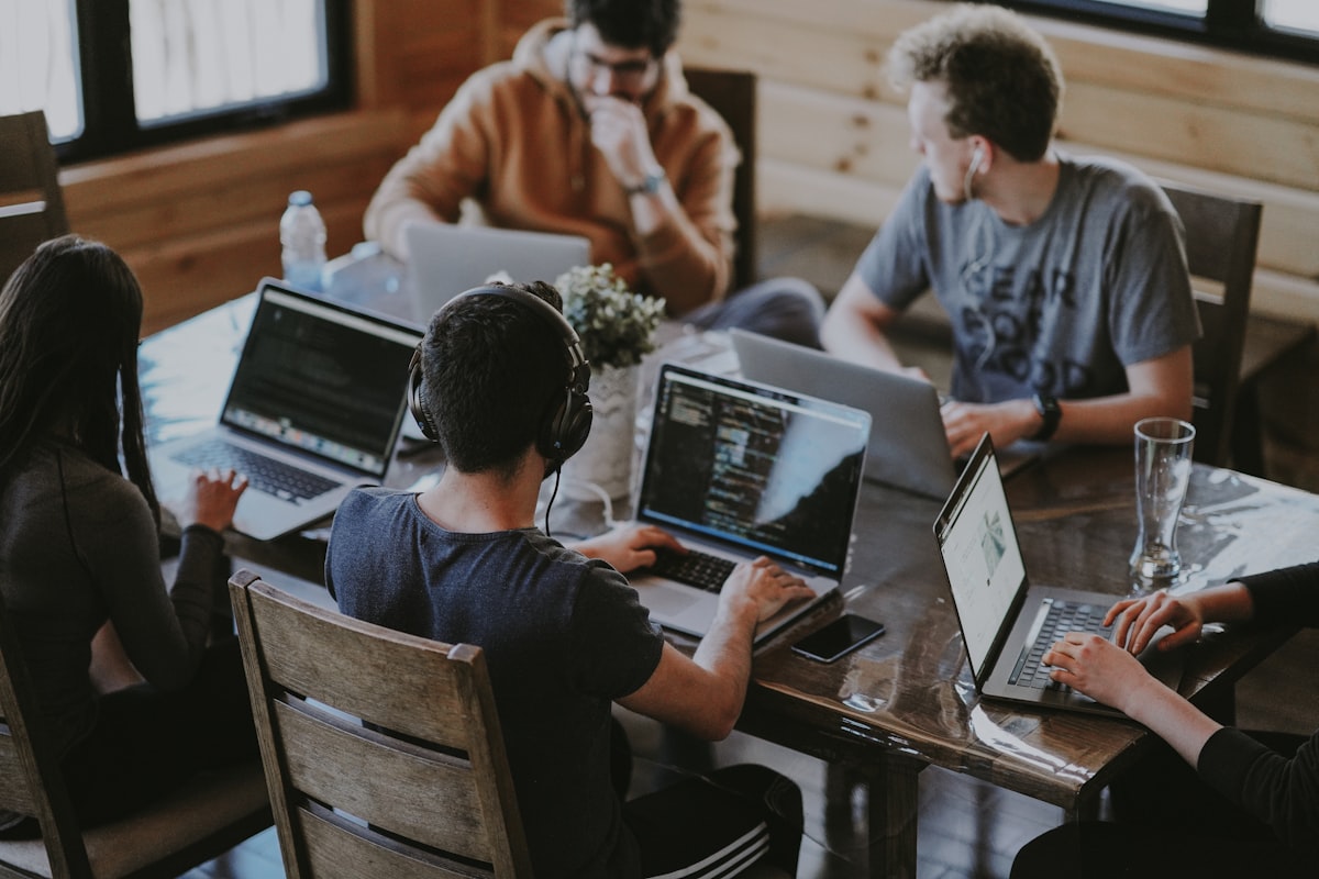 A small team collaborating around a laptop