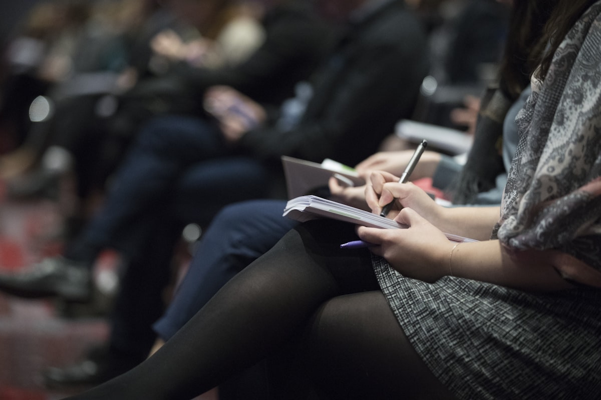 An audience taking notes at an event, where good writing often starts